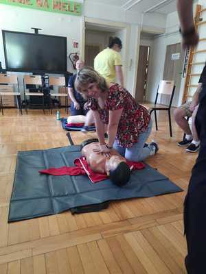 Zdjęcie. Jedna z uczestniczek Warsztatu ćwiczy na fantomie uciśnięcia klatki piersiowej.