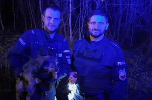 2 policjantów z uratowanym psem.